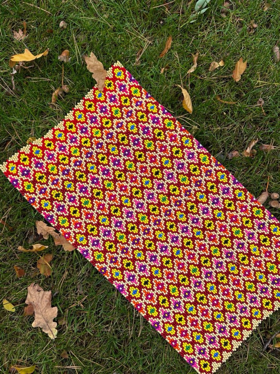 Beaded piece with a grid of small yellow flowers on red